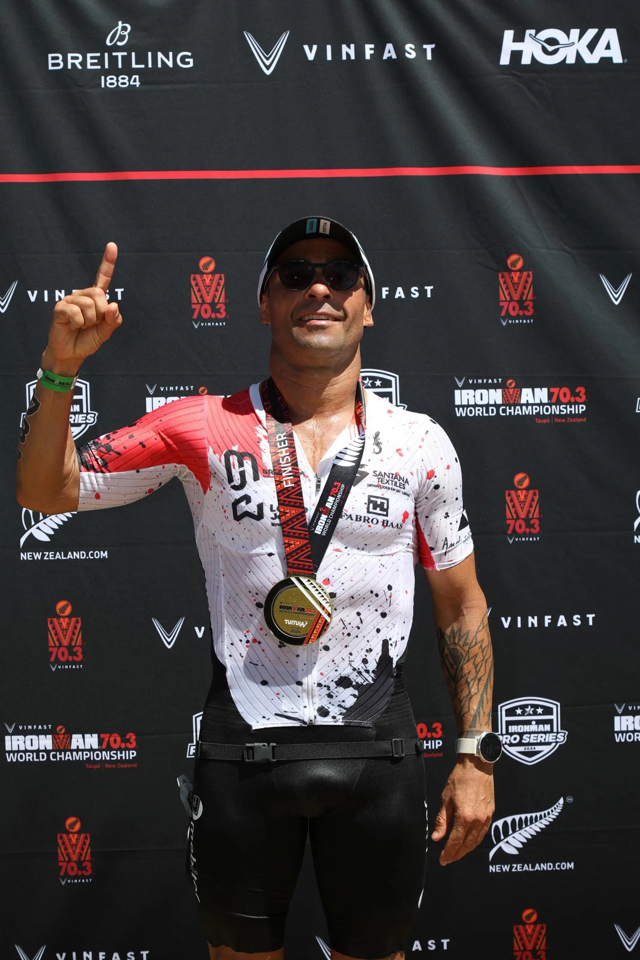 Hermes com a medalha do Mundial em frente ao painel de patrocinadores oficiais